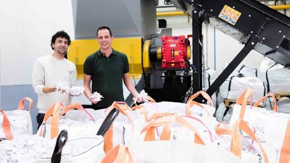 Twee Probo-collega's bij de shredder met big bags vol vermalen plaatmateriaal dat wordt hergebruikt.